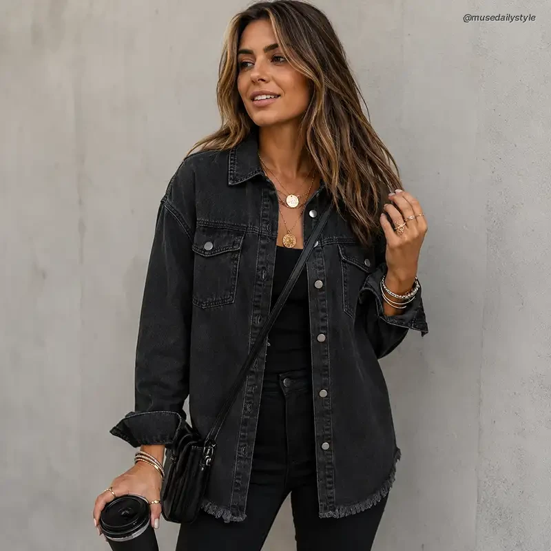 Oversized washed black denim shacket with frayed hem, flap pockets and rolled cuffs worn over an all-black outfit with a black crossbody bag and layered gold necklaces